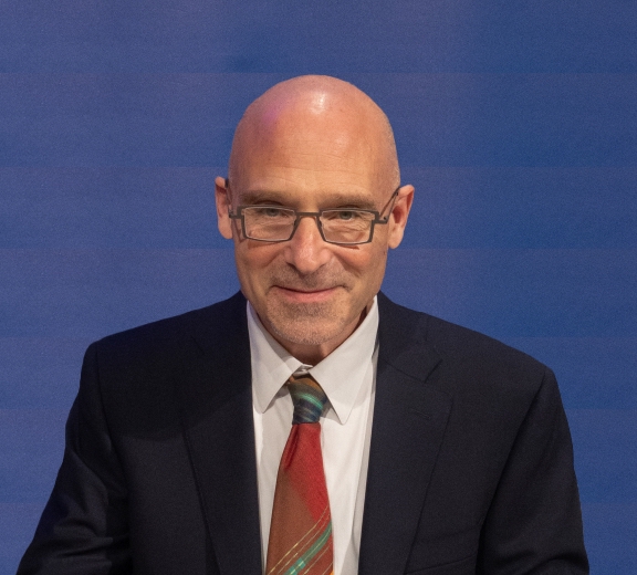David Pellman, wearing a dark suit and a colourful, red tie